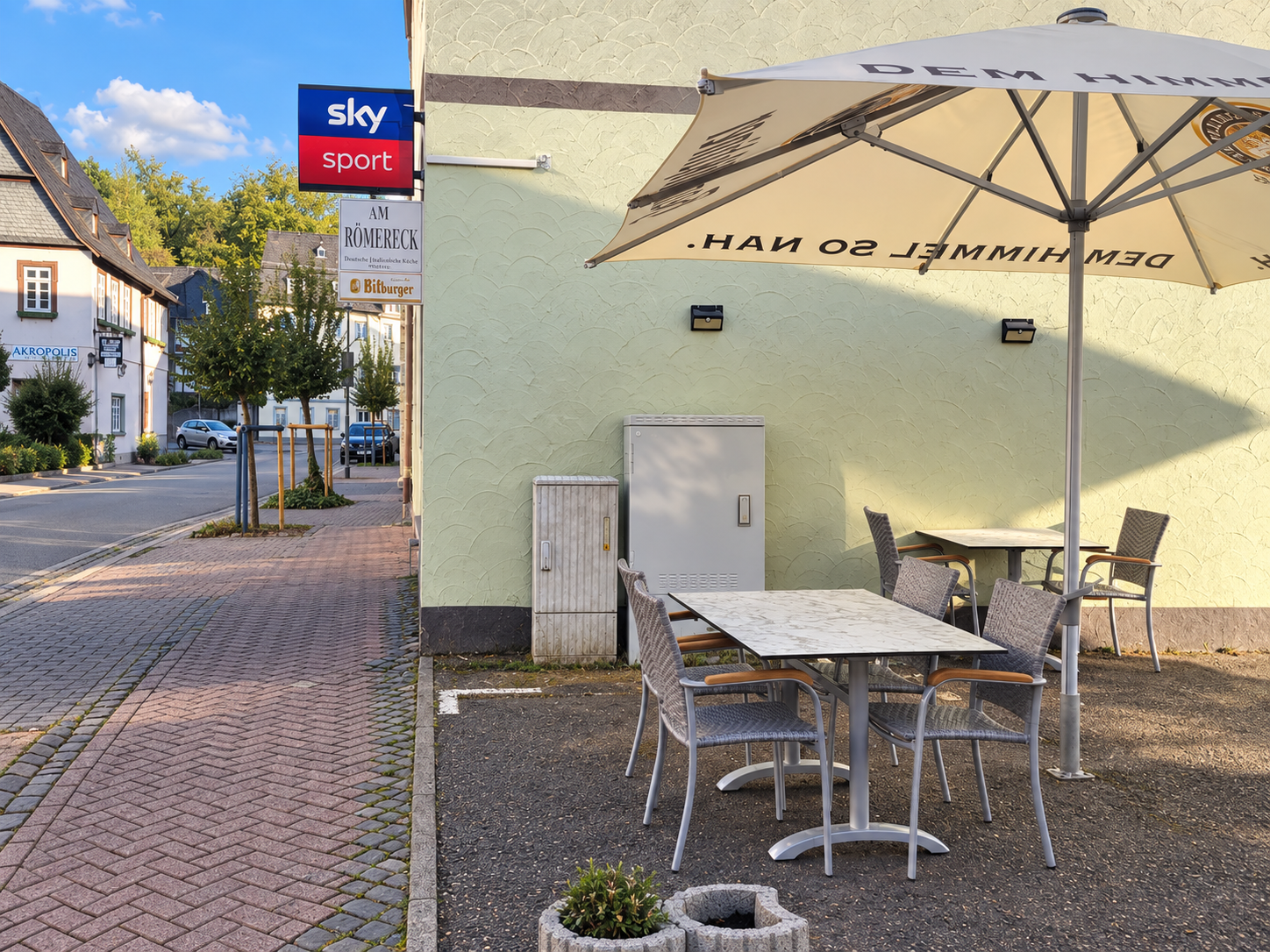 Außensitzplätze am Römereck mit Tischen und Sonnenschirm